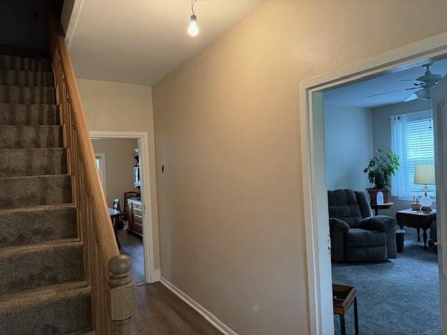 staircase with baseboards and a ceiling fan