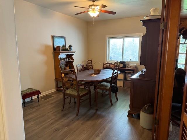 dining area with baseboards, a ceiling fan, and wood finished floors