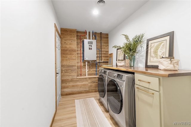 washroom featuring visible vents, tankless water heater, laundry area, light wood-style floors, and independent washer and dryer