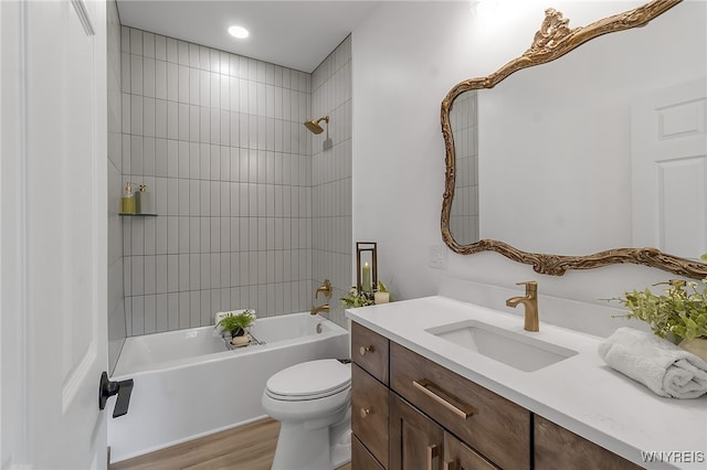 bathroom with bathing tub / shower combination, toilet, wood finished floors, and vanity