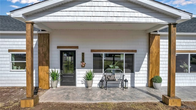 property entrance with a porch and a shingled roof