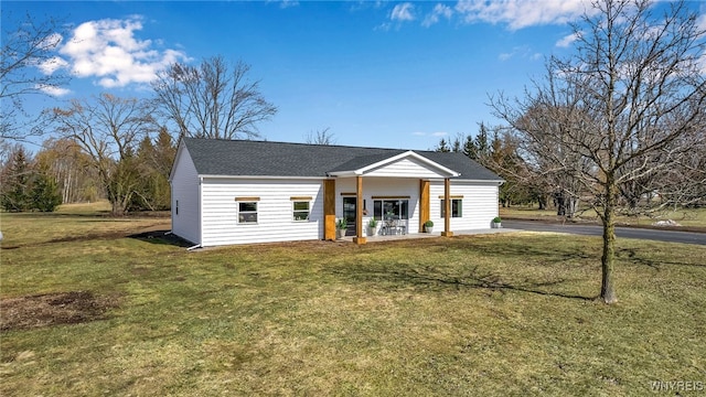 view of front of home featuring covered porch, a front lawn, and roof with shingles