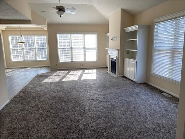 unfurnished living room with a fireplace with flush hearth, carpet, lofted ceiling, and ceiling fan