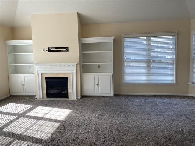 unfurnished living room featuring baseboards, carpet floors, and a fireplace with flush hearth