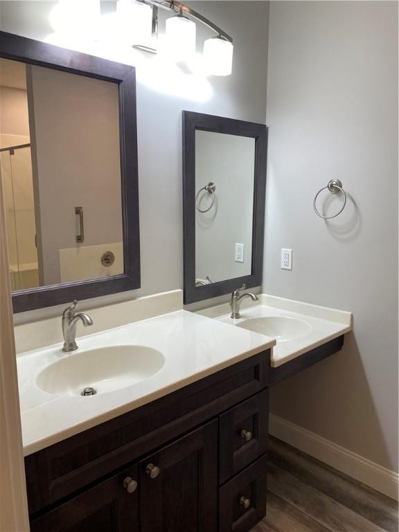 full bathroom featuring baseboards, wood finished floors, and vanity