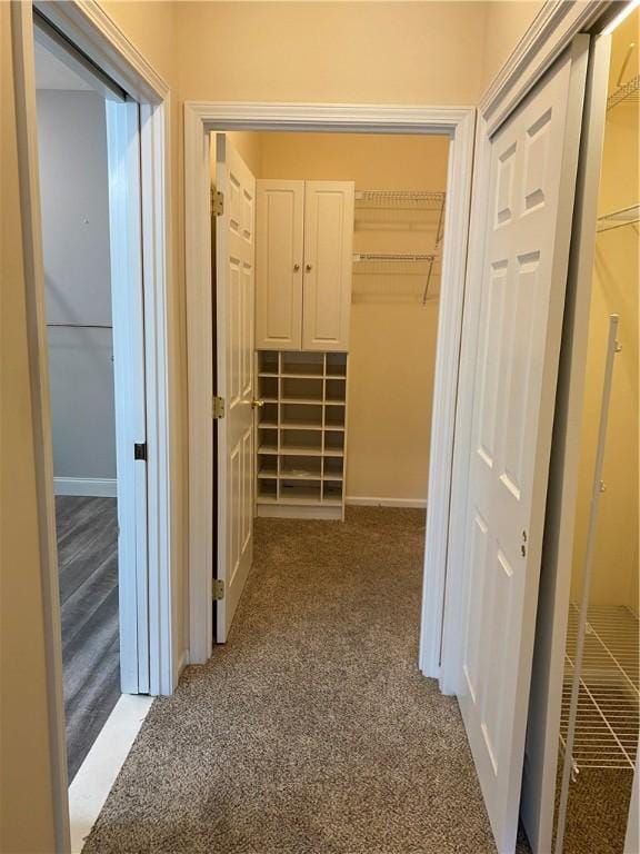 hallway featuring baseboards and light colored carpet