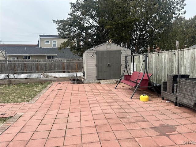 view of patio / terrace with an outdoor structure, a storage shed, and a fenced backyard