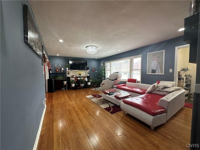 living room with recessed lighting, an inviting chandelier, and wood finished floors