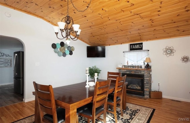 dining area featuring lofted ceiling, wood ceiling, wood finished floors, and arched walkways