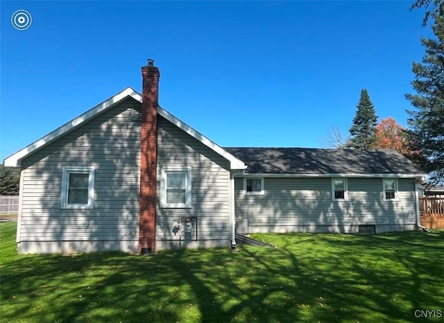 rear view of property with a lawn and a chimney