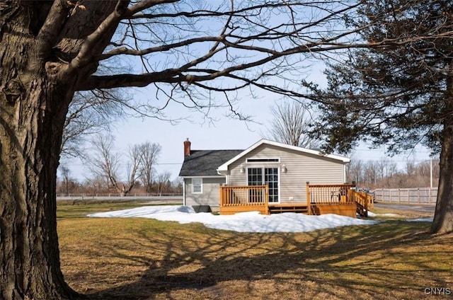 exterior space featuring a yard, a chimney, a deck, and fence