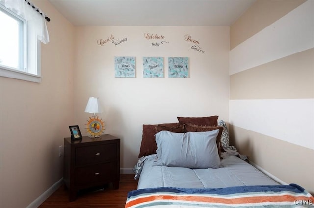 bedroom with baseboards and wood finished floors