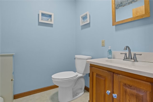 bathroom with toilet, vanity, and baseboards