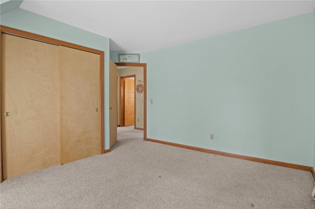 unfurnished bedroom with a closet, baseboards, and carpet