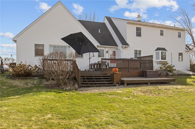 rear view of property featuring a deck and a yard