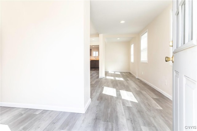 corridor with recessed lighting, baseboards, and light wood-type flooring