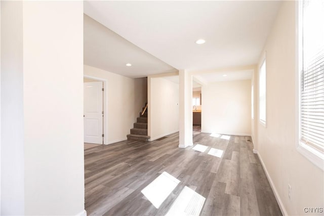 spare room featuring stairs, plenty of natural light, wood finished floors, and recessed lighting