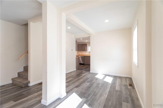 unfurnished living room featuring visible vents, wood finished floors, recessed lighting, baseboards, and stairs