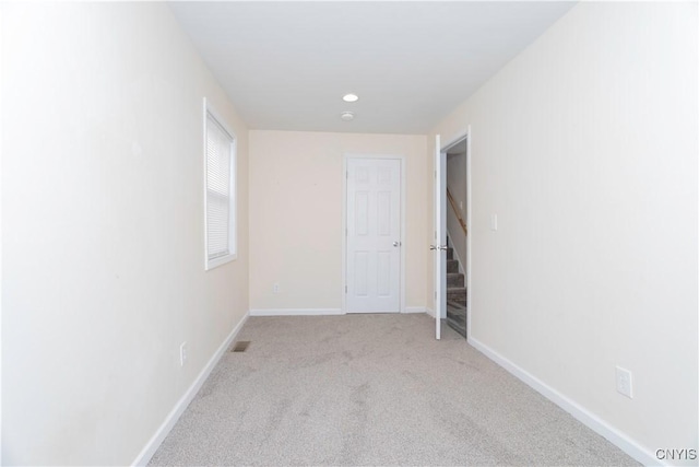 carpeted empty room with recessed lighting, visible vents, and baseboards