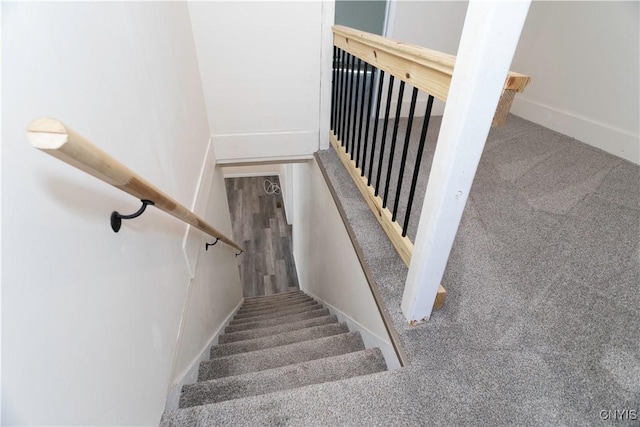 staircase with baseboards and carpet