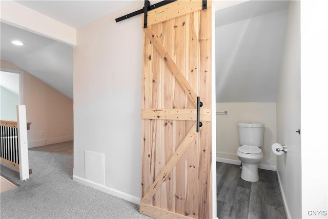 bathroom with baseboards, toilet, and lofted ceiling