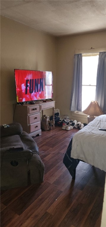 bedroom with a textured ceiling and wood finished floors