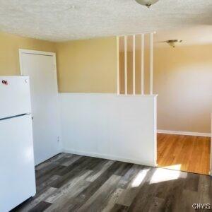 interior space featuring a textured ceiling, baseboards, and wood finished floors