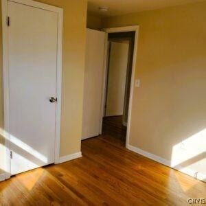 unfurnished room with baseboards and wood finished floors