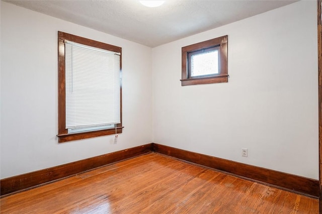 empty room featuring wood finished floors and baseboards