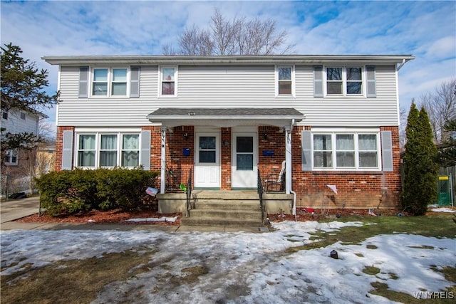 view of front facade featuring brick siding and a porch