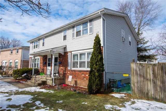 view of front of property featuring brick siding and fence