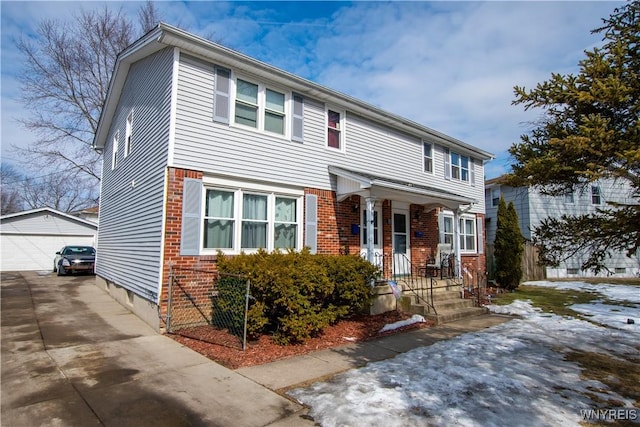 view of front of property with a detached garage, brick siding, and an outdoor structure