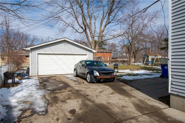 snow covered garage with a detached garage