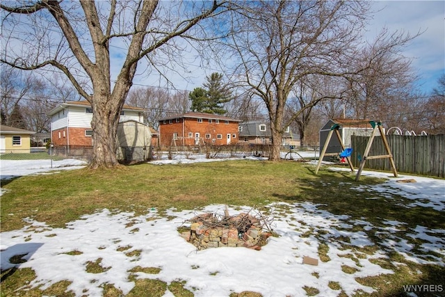 snowy yard with a playground and fence