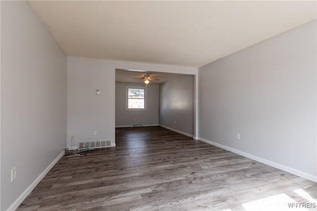 unfurnished room with visible vents, baseboards, a ceiling fan, and wood finished floors