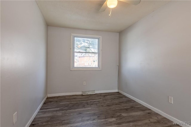 unfurnished room with ceiling fan, visible vents, baseboards, and wood finished floors