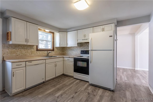 kitchen featuring a sink, white appliances, under cabinet range hood, and white cabinetry