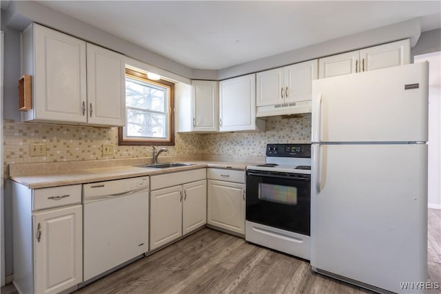 kitchen with under cabinet range hood, white appliances, white cabinetry, and a sink