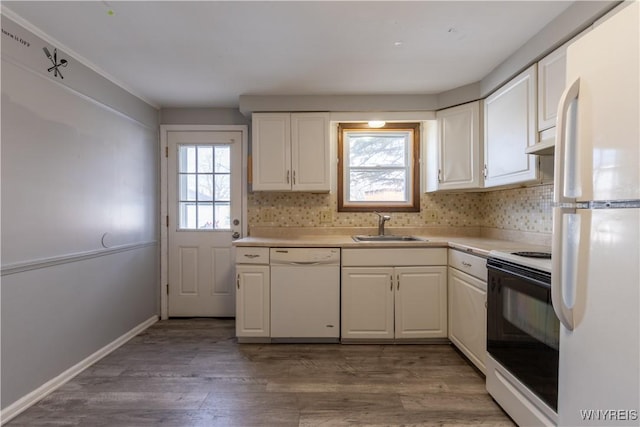 kitchen featuring light countertops, light wood-style flooring, white appliances, white cabinetry, and a sink