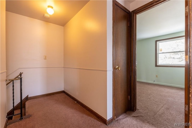 hallway featuring baseboards and carpet floors