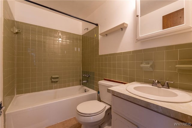 bathroom with vanity, washtub / shower combination, wainscoting, tile walls, and toilet