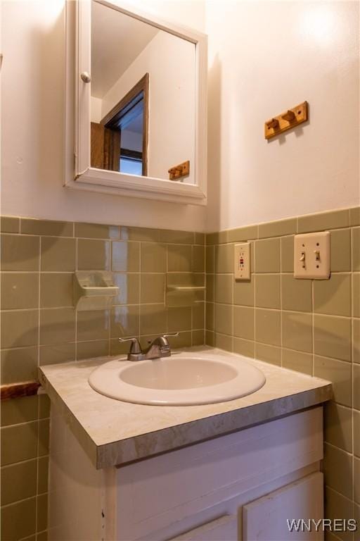 bathroom featuring tile walls, wainscoting, and vanity