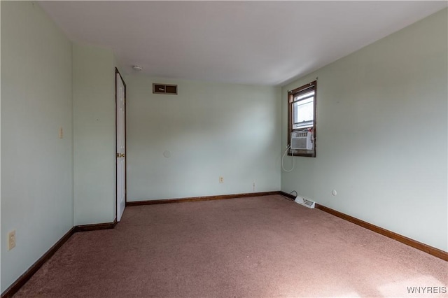 carpeted spare room with visible vents, baseboards, and cooling unit