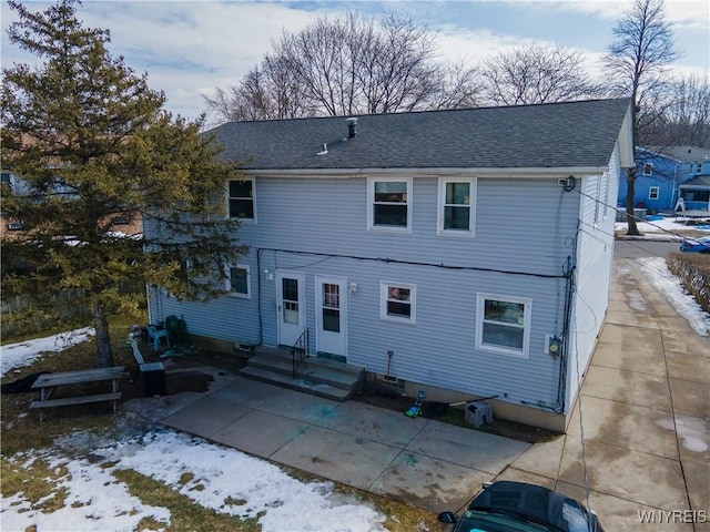 back of house with a patio area, entry steps, and roof with shingles