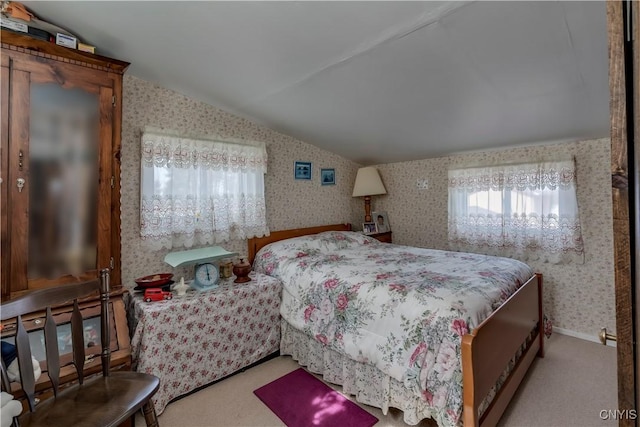 carpeted bedroom featuring wallpapered walls, baseboards, and vaulted ceiling