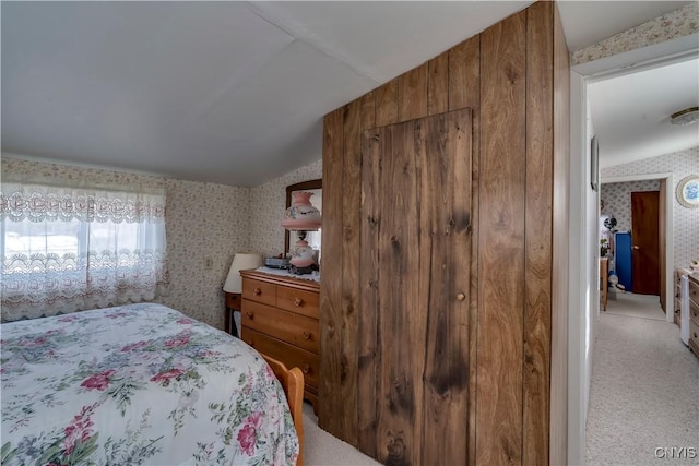 bedroom with wallpapered walls, vaulted ceiling, and carpet floors