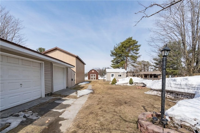 view of yard featuring an outbuilding, a storage unit, and a garage