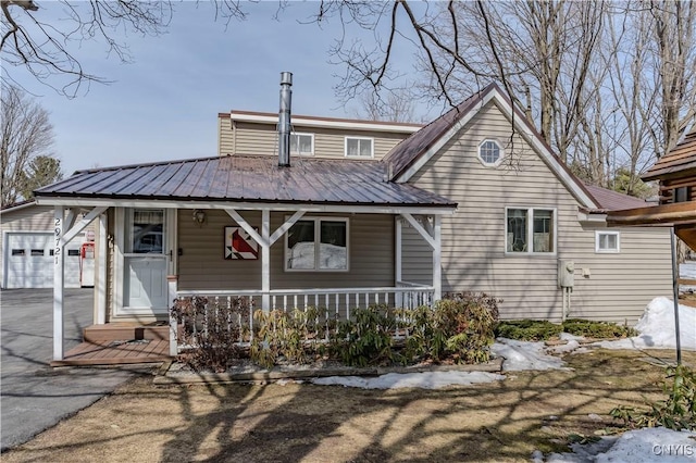 bungalow-style home featuring a porch and metal roof