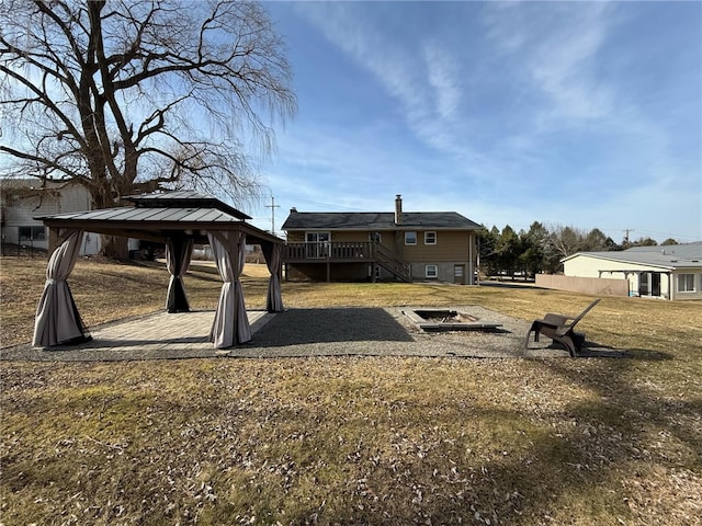 view of yard with a gazebo, a wooden deck, a fire pit, and stairs