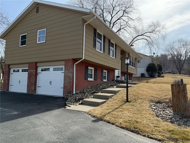 view of property exterior with brick siding, a garage, and driveway